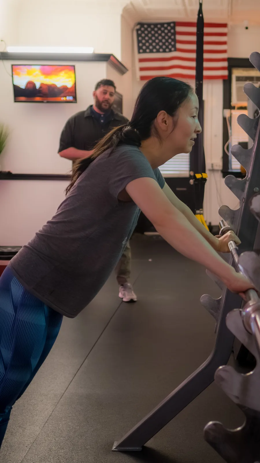 Trainer observing a client during a private exercise session